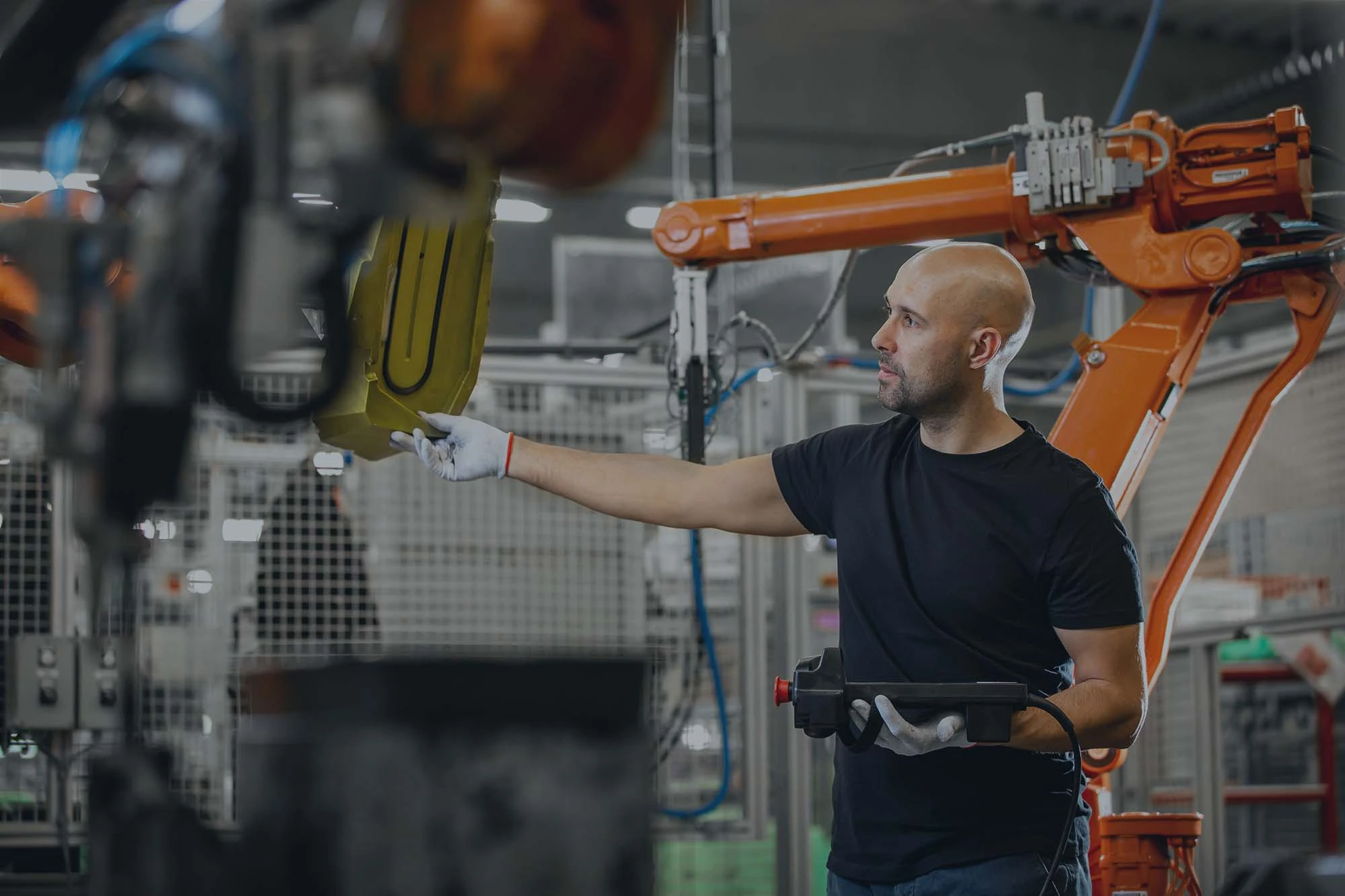 trabajador de la industria automovilística revisando brazo robótico