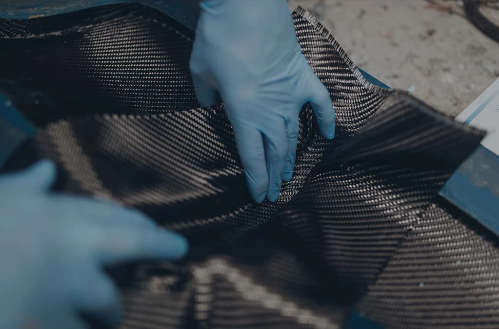 worker laying a carbon fiber coating